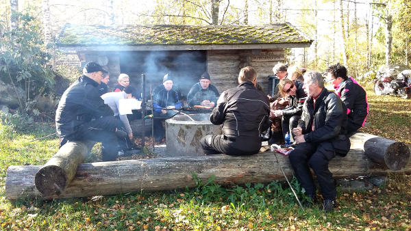Kerhon jäseniä laavun tulipaikan ympärillä. Mukanan myös muutama vieraileva tähti.